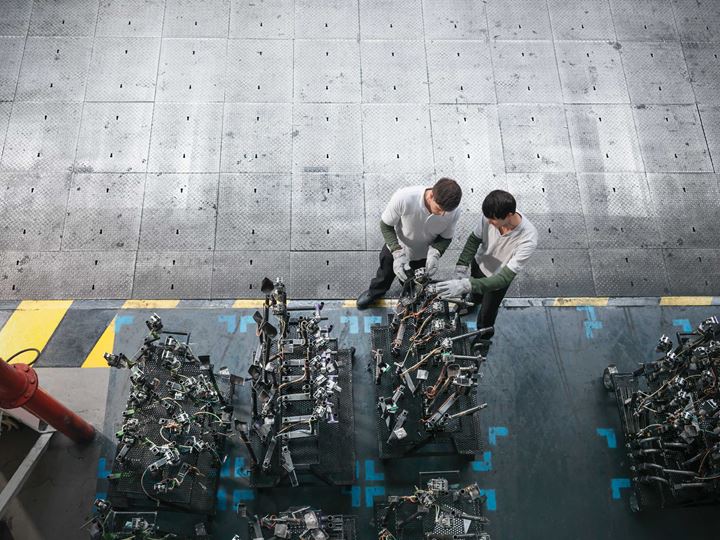 Two engineers working machine parts